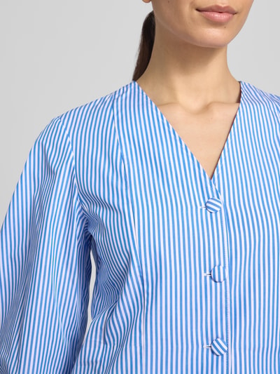 Frauenmodel trägt Bluse mit V-Ausschnitt und Knopfleiste von Rich & Royal, taillierter Schnitt, reine Baumwolle, blau-weiß gestreift, Nahaufnahme Oberkörper