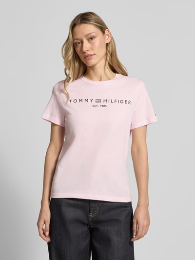 Frauenmodel trägt Regular Fit T-Shirt aus reiner Baumwolle von Tommy Hilfiger in Optik: Unifarben, Logo-Detail, Label-Schriftzug, Rundhals, Kurzarm, Jersey; Nahaufnahme Oberkörper.