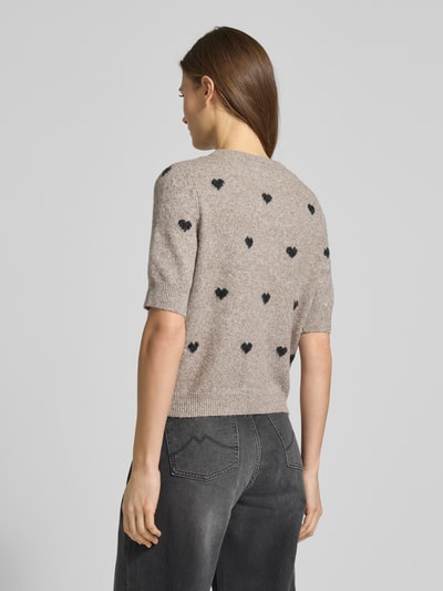 Frauenmodel trägt Slim Fit Strickjacke mit Intarsien Modell 'DOFFY INTARSIA' von Vero Moda, Unifarben, florales Allover-Muster, Strick, Ganzkörperansicht Rückansicht.