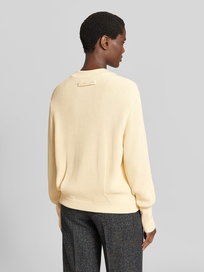 Frauenmodel trägt Relaxed Pullover mit Viskose-Anteil von Victoria Beckham in Creme mit Strick-Optik, breite Ärmelabschlüsse, Rückenansicht. Baumwoll-Mix, Relaxed Fit.