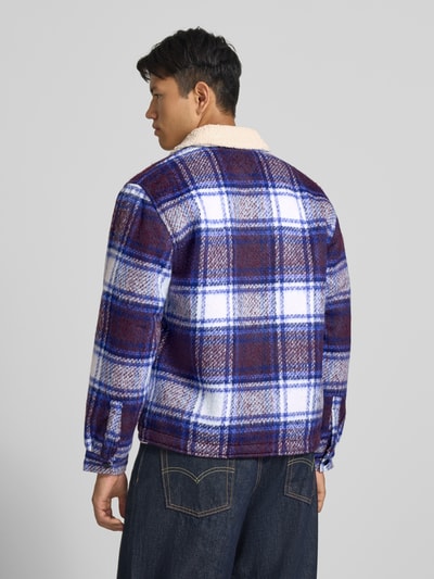 Männermodel trägt Oversized Hemdjacke mit Umlegekragen Modell 'TEDDY COLLAR BRUSHED' von Tommy Jeans, kariertes Muster in Blau, Weiß und Rot, grobe Textur, Ganzkörperansicht Rückansicht, Herren Hemdjacke von Tommy Jeans.