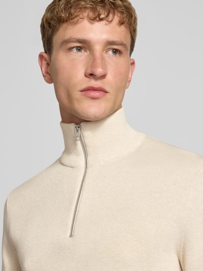 Männermodel trägt Slim Fit Pullover aus reiner Baumwolle Modell 'MILANO' von JACK & JONES in Beige mit Troyer-Kragen, Nahaufnahme Oberkörper.