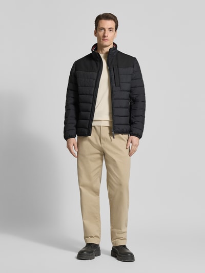 Männermodel trägt Regular Fit Steppjacke mit seitlichen Stretcheinsätzen von Tom Tailor, Optik: Unifarben, Ganzkörperansicht von vorne.