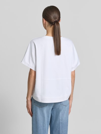 Frauenmodel trägt Oversized T-Shirt mit Rundhalsausschnitt von Smith and Soul aus reiner Baumwolle, weiße Farbe, Tunnelzug, Rückenlänge 57 cm, ganzkörperansicht rückansicht.