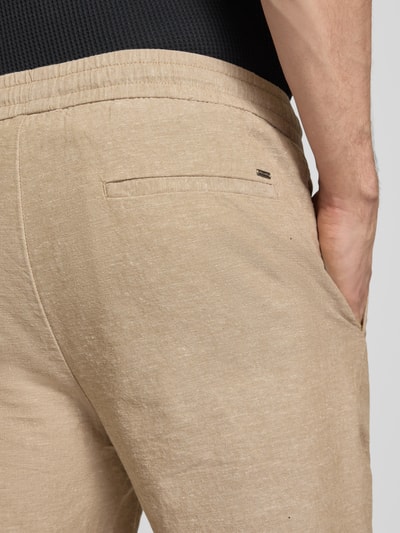 Männermodel trägt Regular Fit Bermudas aus Baumwoll-Leinen-Mix Modell 'LINUS' von Only & Sons, efekt: jednolity kolor, elastyczny ściągacz, wpuszczane kieszenie i kieszeń z tyłu, mieszanka bawełny i lnu, detailaufnahme tylnej części.