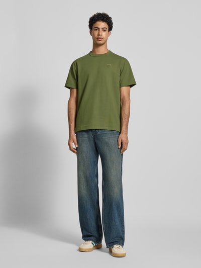 Männermodel trägt Regular Fit T-Shirt mit Strukturmuster von G-Star Raw in Grün mit Rundhalsausschnitt und Logo, Ganzkörperansicht von vorne. Herren T-Shirt, Rückenlänge bei Größe M: 71 cm.