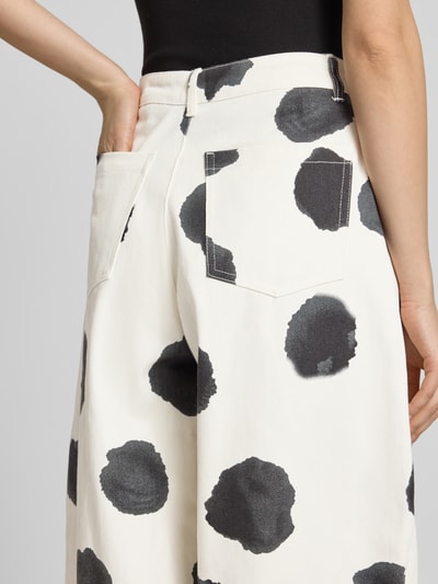 Frauenmodel trägt Barrel Fit Jeans im Allover-Look Modell 'YARA' von Topshop in Creme mit schwarzen Punkten, Nahaufnahme Rückansicht, High Waist, Bundweite 34 cm, Innenbeinlänge 75 cm.