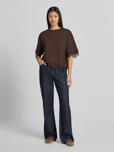Frauenmodel trägt T-Shirt mit Spitzenbesatz von Smith and Soul in Dunkelbraun, kombiniert mit Jeans; reine Baumwolle, gerader Schnitt, Ganzkörperansicht von vorne.