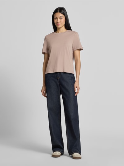 Vrouwenmodel draagt Regular Fit T-Shirt uit puur katoen van s.Oliver RED LABEL in lichtbruin, gecombineerd met donkerblauwe jeans, volledige lichaamsaanzicht van voren.