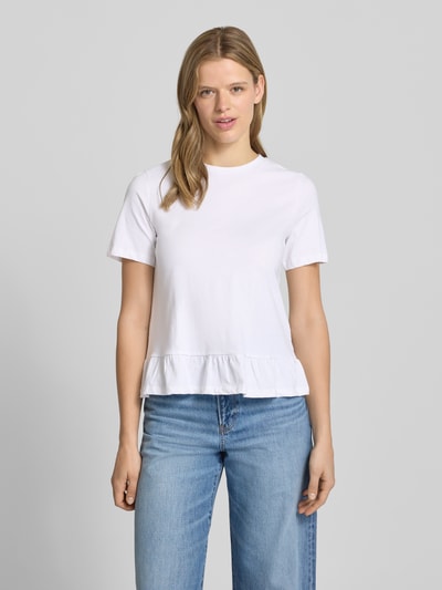 Frauenmodel trägt Regular Fit T-Shirt aus reiner Baumwolle Modell 'DISSO' von Pieces, unifarben weiß mit Rüschenbesatz, Ganzkörperansicht von vorne.