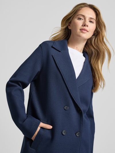 Vrouwenmodel draagt Mantel mit Reverskragen und Eingrifftaschen van WHITE LABEL in donkerblauw, regular fit, katoenmix met stretch, dubbele rij knopen, reverskraag, steekzakken, detailopname bovenlichaam.