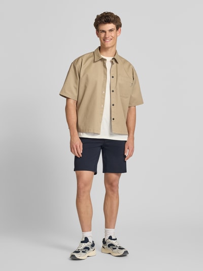 Männermodel trägt Regular Fit Chinoshorts aus Viskose-Mix Modell 'MARK' von Only & Sons in Melange-Optik, Eingrifftaschen, Ganzkörperansicht von vorne.