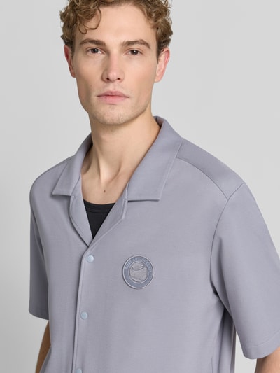 Męski model nosi jasnoszarą koszulę casualową Relaxed Fit z mieszanki wiskozy model 'ST_UNION S' od BOSS Green, zbliżenie na górną część ciała.