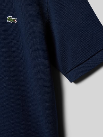 Mädchen trägt Regular Fit Regular Fit aus reiner Baumwolle von Lacoste, Optik: Unifarben, Logo-Stitching, Piqué, Nahaufnahme Oberkörper.