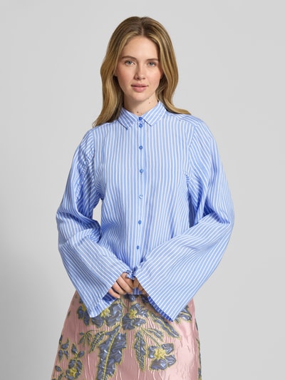 Frauenmodel trägt Relaxed Fit Bluse aus Viskose-Mix von Milano Italy in Hellblau-Weiß mit Hemdblusenkragen und Tunnelzug-Ärmel, Nahaufnahme Oberkörper, Rückenlänge 57 cm, Ärmellänge 68 cm bei Größe 36.