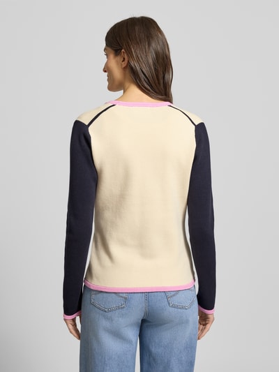 Frauenmodel trägt Regular Fit Cardigan aus reiner Baumwolle von Christian Berg Woman, imitacja dzianiny, ozdobne guziki, dekolt w serek, krój regular fit, długość tyłu 60 cm, długość rękawów 64 cm, kolor kremowy z ciemnogranatowymi rękawami i różowymi lamówkami, Ganzkörperansicht Rückansicht.