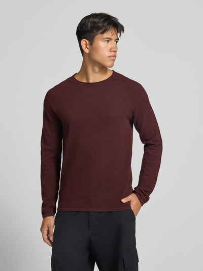 Männermodel trägt Regular Fit Pullover aus reiner Baumwolle Modell 'Hill' von JACK & JONES in Dunkelrot, Strick-Optik, Nahaufnahme Oberkörper. Rückenlänge 69 cm, Ärmellänge 70 cm.