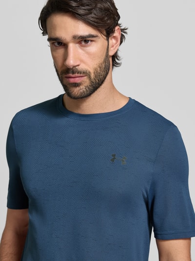 Męski model nosi Slim Fit T-Shirt mit Logo-Print Modell 'Vanish' od Under Armour, niebieski z okrągłym dekoltem, dziurkowany wzór, krój slim fit, szerokość w rozmiarze M: 40 cm, zdjęcie: zbliżenie górnej części ciała