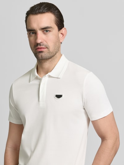 Männermodel trägt Slim Fit Polo-Shirt mit Logo-Applikation von Antony Morato in Weiß aus reiner Baumwolle, Nahaufnahme Oberkörper.