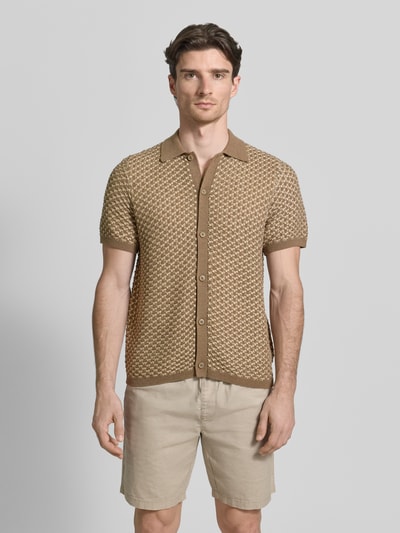 Männermodel trägt Regular Fit Freizeithemd mit Knopfleiste Modell 'RYDEN' von Guess, Material-Mix mit Leinen-Anteil, Kentkragen, 1/2-Arm, beige gemusterte Textur, Rückenlänge 65 cm, Schulterbreite 44 cm, Ärmellänge 25 cm, Ganzkörperansicht von vorne.
