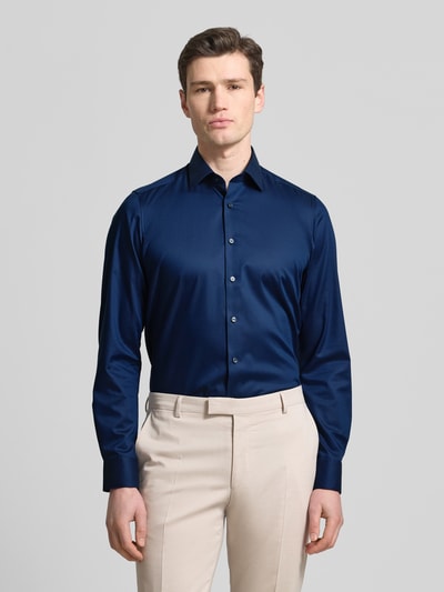 Männermodel trägt Slim Fit Business-Hemd mit Strukturmuster und Kentkragen von OLYMP Level Five, dunkelblau, Unifarbe, Ganzkörperansicht von vorne. Baumwoll-Mix mit Stretch-Anteil, klassische Knopfleiste, lange Ärmel, schlichte Oberflächenstruktur, gepflegter Business-Look.