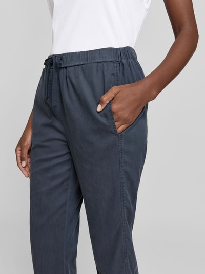 Frauenmodel trägt Stoffhose mit Lyocell-Anteil von Juvia in Dunkelblau, Baumwoll-Mix, elastischer Bund mit Tunnelzug, Nahaufnahme Oberkörper.