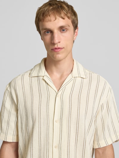 Männermodel trägt Regular Fit Freizeithemd mit Strukturmuster Modell 'COBA' von Jack & Jones aus Baumwoll-Mix, Nahaufnahme Oberkörper. Rückenlänge 73 cm, Schulterbreite 40 cm, Ärmellänge 24 cm, beige mit braunen Streifen, sichtbare Knopfleiste, fühlbare Textur.