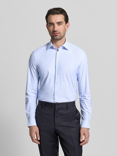 Männermodel trägt Slim Fit Business-Hemd mit Kentkragen von Jake*s, hellblau, Elastischer-Material-Mix, durchgehende Knopfleiste, Langärmelig, Sportmanschetten, Ganzkörperansicht von vorne.