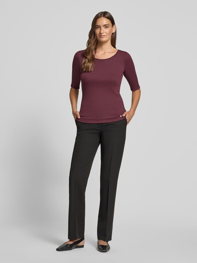 Frauenmodel trägt Damen T-Shirt mit Rundhalsausschnitt und Label-Detail von Marc Cain, Baumwoll-Elasthan-Mix, Slim-Fit, Rückenlänge 55 cm, Ganzkörperansicht von vorne.