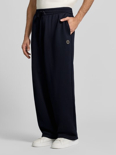 Männermodel trägt Wide Fit Sweathose mit elastischem Bund von Armani Exchange in Dunkelblau, Baumwoll-Mix, Eingrifftaschen, Ganzkörperansicht von vorne.