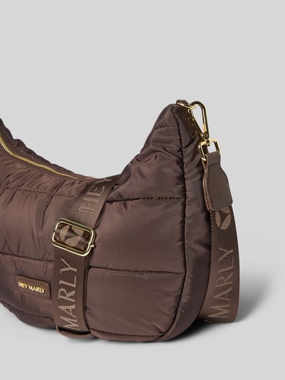 Produktfoto, Bauchtasche mit Steppnähte Modell 'Lifetime Buddy' von Hey Marly in Braun, Label-Detail, goldfarbene Beschläge, sichtbarer Schriftzug, Struktur durch Steppnähte, abnehmbarer, verstellbarer Schulterriemen, Reißverschluss am Hauptfach, Innenfach ebenfalls mit Reißverschluss, Maße 34x28x11 cm, Schulterriemen 112 cm.