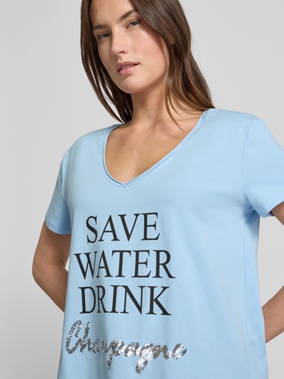 Frauenmodel trägt T-Shirt mit Statement-Print von miss goodlife in Hellblau, lockerer Schnitt, V-Ausschnitt, Nahaufnahme Oberkörper