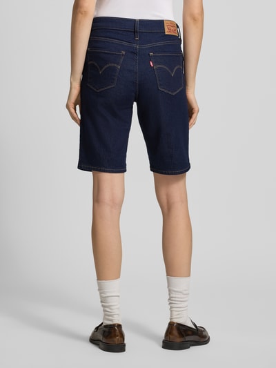 Kobiece model nosi Bermuda mit 5-Pocket-Design von Levi's® 300 z tkaniną stylizowaną na denim, krój slim fit, mieszanka bawełny, widok całej sylwetki z tyłu.
