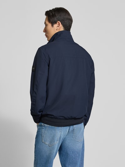 Männermodel trägt Comfort Fit Blouson mit geripptem Rumpfabschluss von Tom Tailor, Optik: Unifarben, wasserabweisend, Rückenpasse, Ganzkörperansicht Rückansicht.