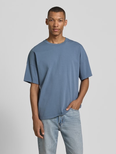 Männermodel trägt T-Shirt mit geripptem Rundhalsausschnitt Modell 'FIZVALLEY' von American Vintage, blau, Baumwolle, Loose Fit, Ganzkörperansicht von vorne.
