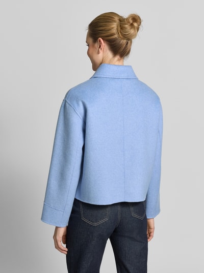 Frauenmodel trägt Jacke mit aufgesetzten Taschen Modell 'Helia' von OPUS in Hellblau, Baumwoll-Mix, Relaxed Fit, Ganzkörperansicht Rückansicht.