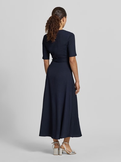 Frauenmodel trägt Wickelkleid mit V-Ausschnitt und Bindegürtel von Zero in Dunkelblau, Material-Mix mit Stretch-Anteil, A-Linie, Midikleid, Rückenlänge bei Größe 36: 100 cm, Brustweite: 40 cm, Ärmellänge: 29 cm, Ganzkörperansicht Rückansicht.