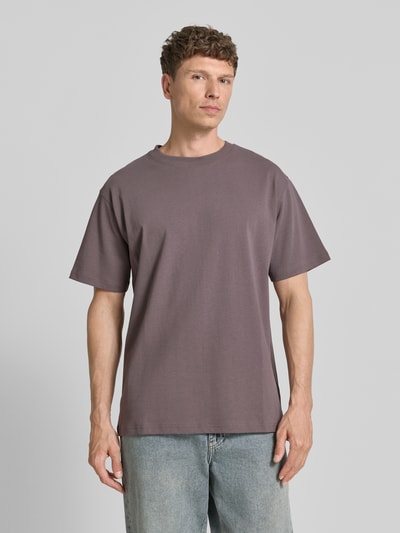 Männermodel trägt Relaxed Fit T-Shirt aus reiner Baumwolle Modell 'MAARKOS HEAVY WEIGHT' von Armedangels, einfarbig, Rundhals, kurzarm, Jersey-Textur, Logo-Stitching dezent, Ganzkörperansicht von vorne.