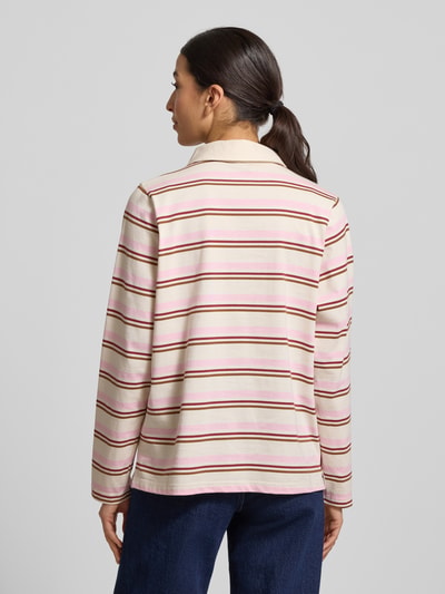 Frauenmodel trägt Poloshirt aus reiner Baumwolle von Soyaconcept in Beige mit rosa und roten Streifen, gerader Schnitt, Ganzkörperansicht Rückansicht.