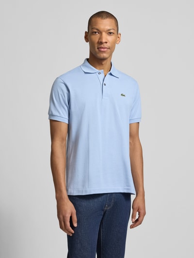 Männermodel trägt Regular Fit Poloshirt aus reiner Baumwolle von Lacoste, look: effen, pasvorm: regular fit, logostitching, polokraag, korte mouw, mouwboord, rompzoom met zijsplitten, materiaalverwerking: piqué, puur katoen, Ganzkörperansicht von vorne.
