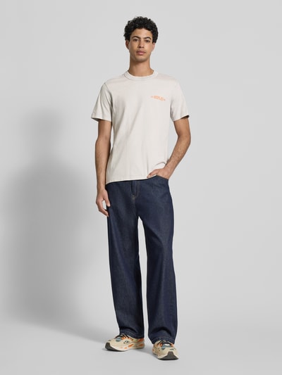 Męski model nosi Regular Fit T-Shirt mit Logo-Print od Replay, bawełna, krój regular fit, okrągły dekolt, długość pleców w rozmiarze M: 63 cm, widok całej sylwetki z przodu.
