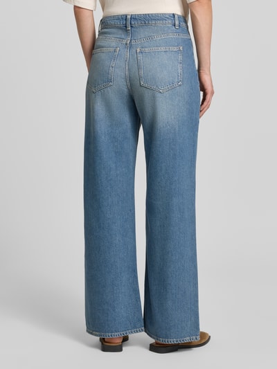 Frauenmodel trägt Wide Fit Jeans mit Lyocell-Anteil von Jake*s Casual in klassischem Blau, breite Beinform, Gesäßtaschen, Ganzkörperansicht Rückansicht. Baumwoll-Mix, aufgesetzte Taschen, Knopf- und Reißverschluss, Bundweite 38 cm, Innenbeinlänge 75 cm bei Größe 36.
