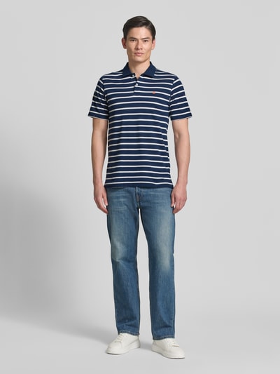 Männermodel trägt Regular Fit Poloshirt mit Logo-Stitching Modell 'Adam' von Jack & Jones Premium, Reine Baumwolle, Kurzärmelig, Polo-Kragen, Ganzkörperansicht von vorne.