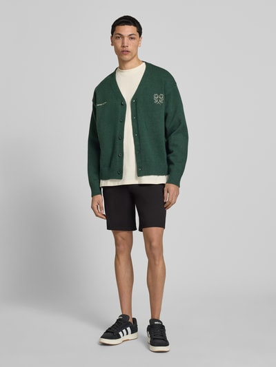 Mannelijk model draagt Regular Fit Bermudas uit viscosemix model 'MARK' van Only & Sons in effen kleuren met steekzakken, labelapplicatie, riemlussen, knoop- en ritssluiting, geweven stretchstructuur, regular fit pasvorm, materiaalverwerking viscosemix, zij- en achterzakken met knoop, look onderstuk, ganzekörperaanzicht van voren.