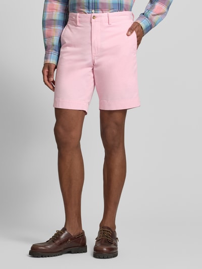 Männermodel trägt Straight Fit Chinoshorts aus Baumwoll-Mix von Polo Ralph Lauren, Optik: Unifarben, Logo-Detail, Gesäßtaschen, Knopf, seitliche Eingrifftaschen, Farbe Rosa, glatte Textur, Ganzkörperansicht von vorne.