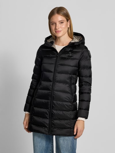 Frauenmodel trägt Mantel in Stepp-Optik Modell 'Agnes' von Blauer USA in Schwarz, körpernahe Passform, Kapuze, Reißverschluss, Logo-Detail, Ganzkörperansicht von vorne.