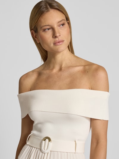 Frauenmodel trägt Cocktailkleid mit Carmen-Ausschnitt Modell 'Capri' von Forever New in Elfenbein, gerippte Textur, Gürtel, Nahaufnahme Oberkörper.
