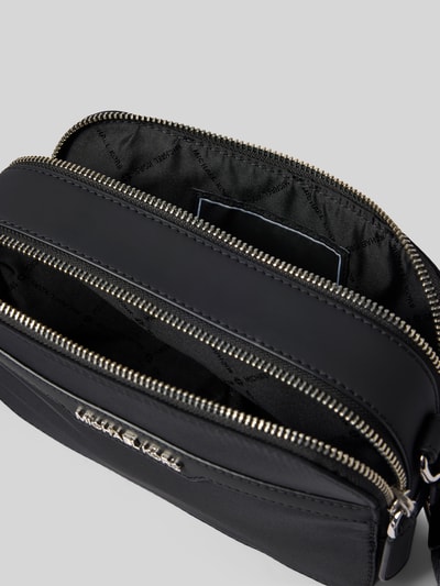 Produktfoto, schwarze Handtasche mit Schulterriemen Modell 'MALONE' von Michael Kors, Reißverschluss, Label-Detail, glatte Struktur, Kontext: Herren Handtasche, Maße 21x14x6 cm, Schulterriemen 104 cm.