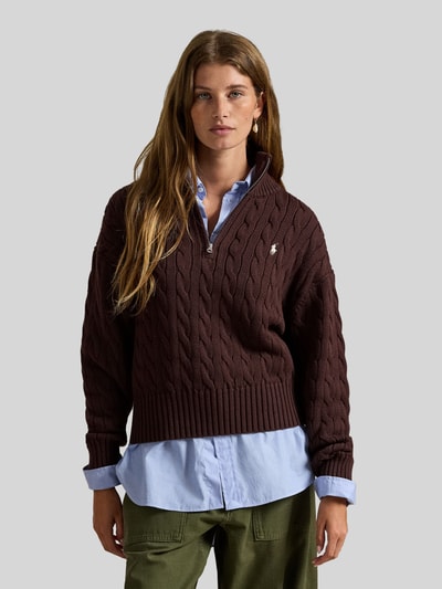 Frauenmodel trägt Troyer mit Zopfstrickmuster von Polo Ralph Lauren in Dunkelbraun, Baumwolle, Regular Fit, Reißverschluss, Nahaufnahme Oberkörper.
