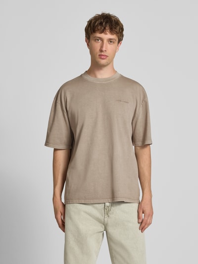 Männermodel trägt Oversized T-Shirt mit Label-Stitching von Pegador aus Baumwoll-Mix, Herren T-Shirt, Rundhalsausschnitt, Ganzkörperansicht von vorne. Rückenlänge bei Größe M: 70 cm.